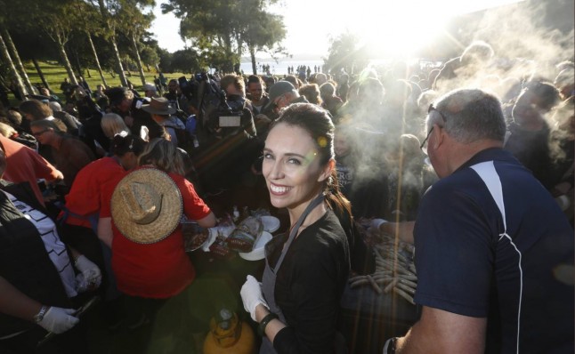A photograph of Jacinda Ardern cooking at a barbeque in New Zealand